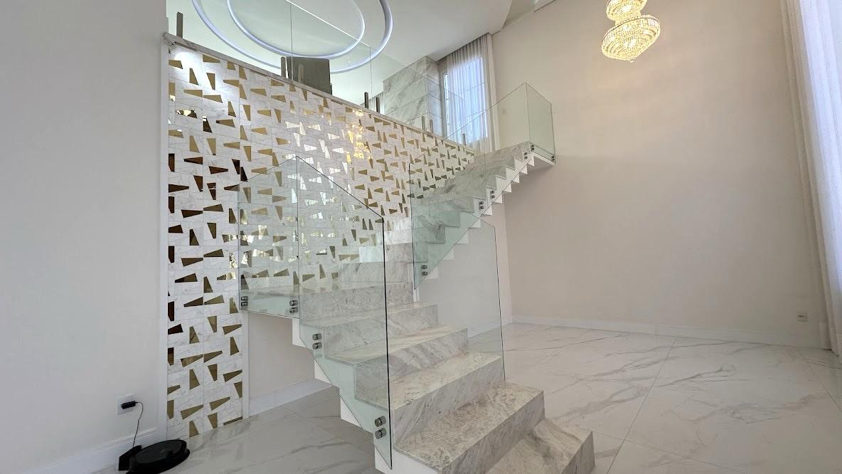 Detalhe da escada de mármore com painel vazado e lustre de cristal