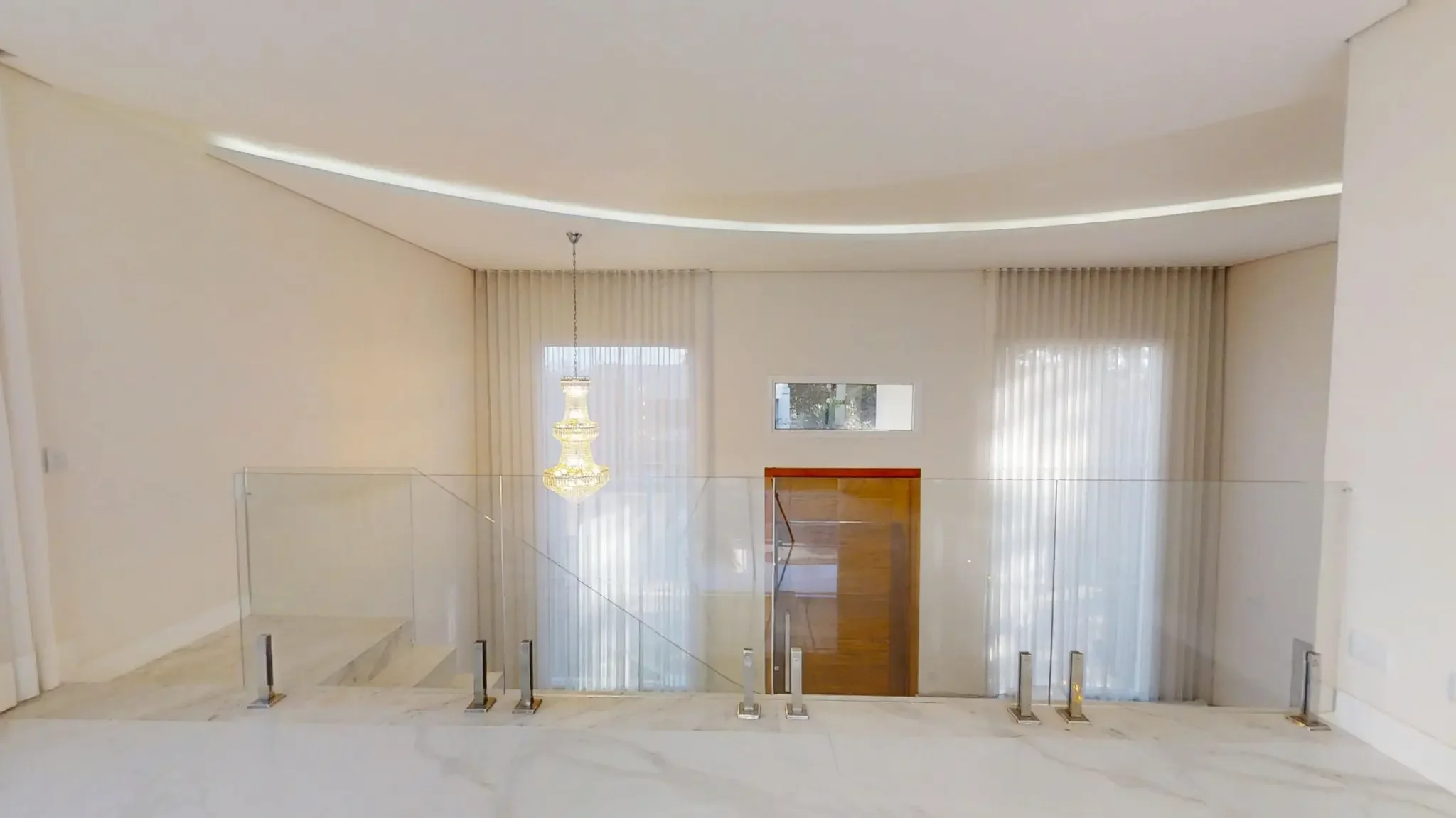 Mezanino com lustre de cristal, cortinas em pé-direito duplo e vista para a porta de entrada