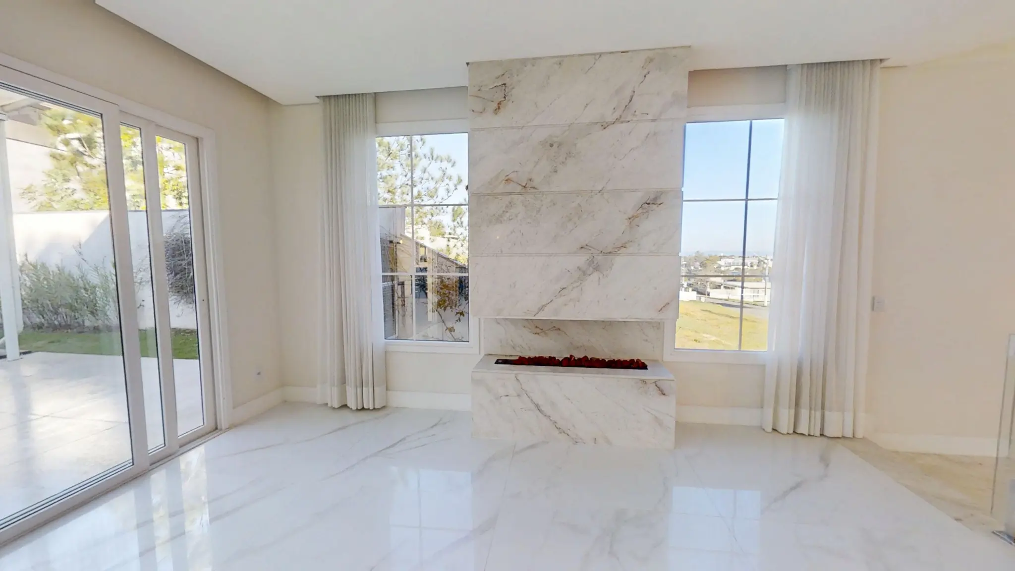 Sala principal com lareira a gás em painel de mármore entre janelas Kömmerling